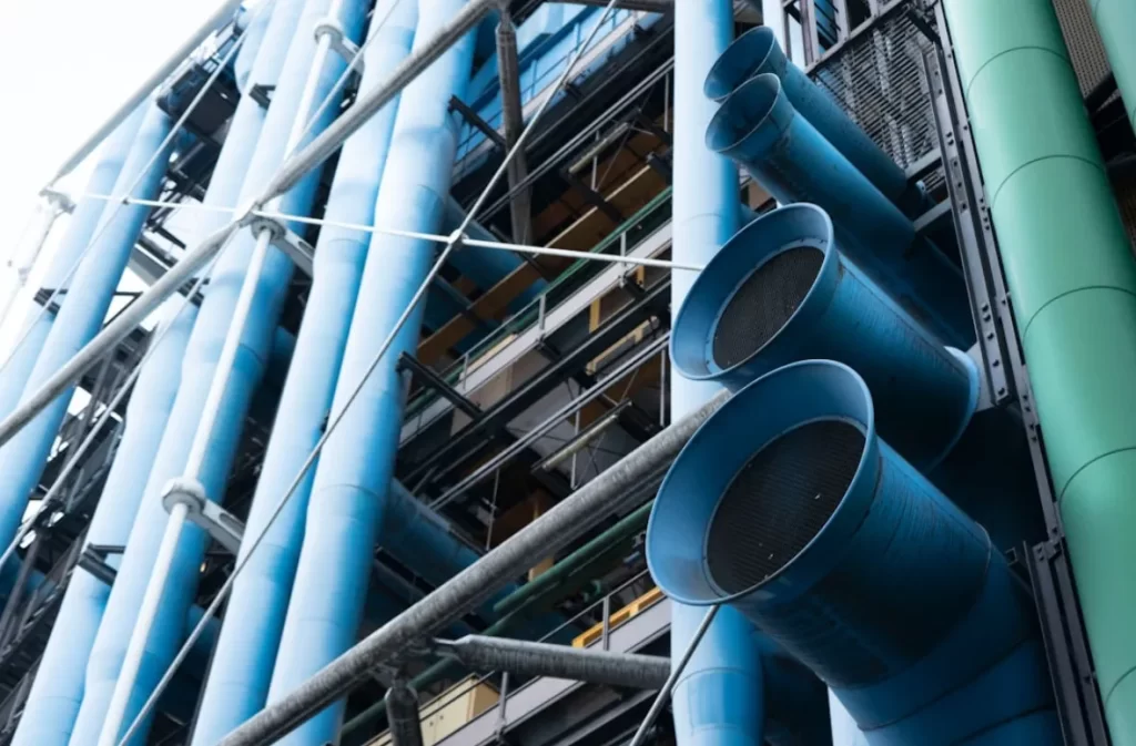 Blue pipelines and exhaust ducts in an industrial setup.