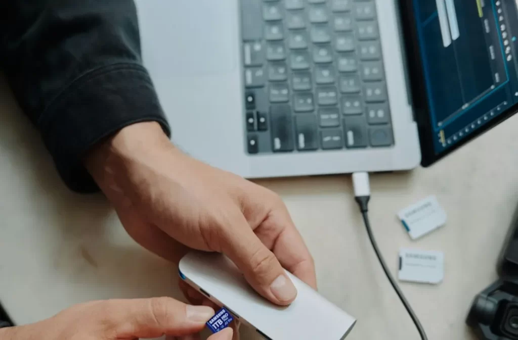 Inserting memory card into external drive for tech job.