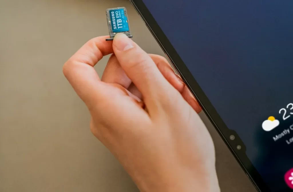 Inserting 1TB card into a tablet for data transfer task.