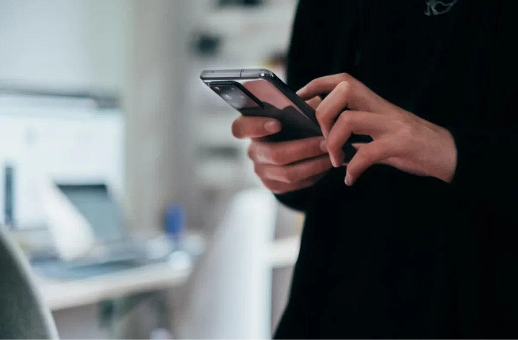 Person using a smartphone at a desk.