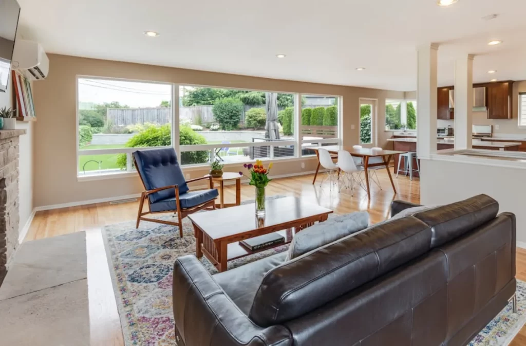 Spacious living room staged with large windows and cozy furniture.