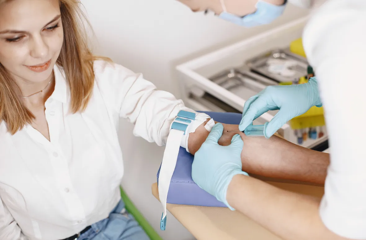 Medical staff assisting in focused blood draw.